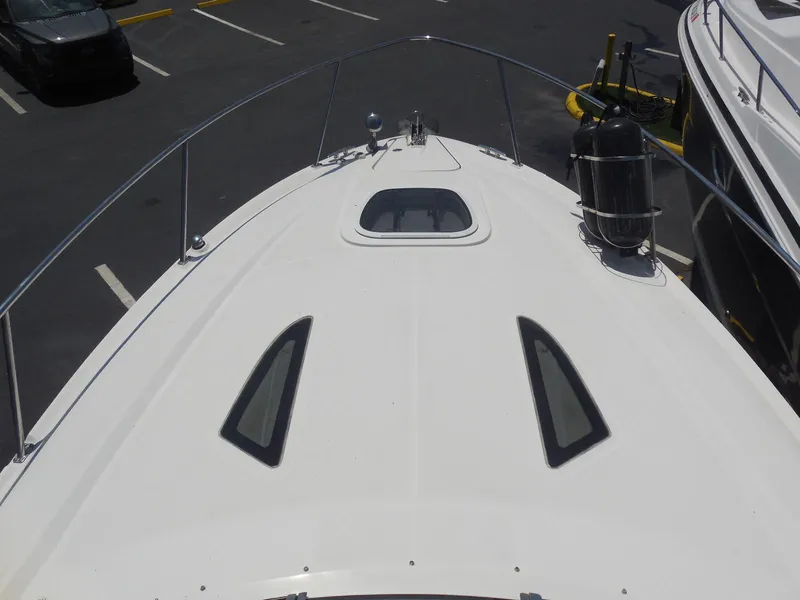 Slide: The Image of 2007 Sea Ray 290 Sundancer boat deck with hatch and railings in a parking area. - 28