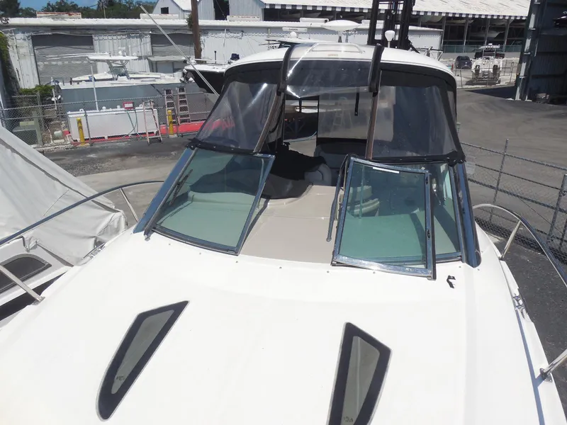 Slide: The Image of 2007 Sea Ray 290 Sundancer boat with windshield and cockpit, docked at a marina. - 32