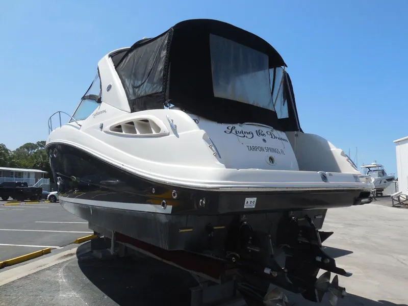 Slide: The Image of 2007 Sea Ray 290 Sundancer boat with black canopy, docked on a sunny day. - 4