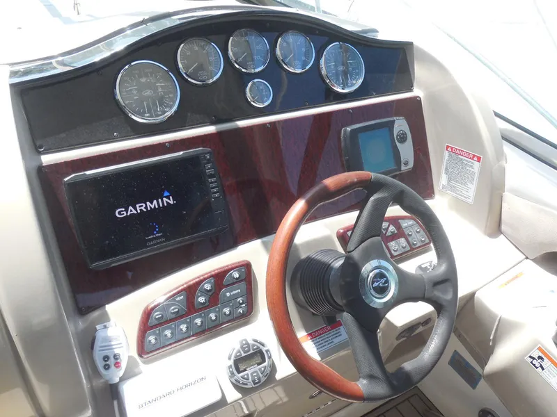 Slide: The Image of 2007 Sea Ray 290 Sundancer helm with Garmin navigation and wood-accented steering wheel. - 43