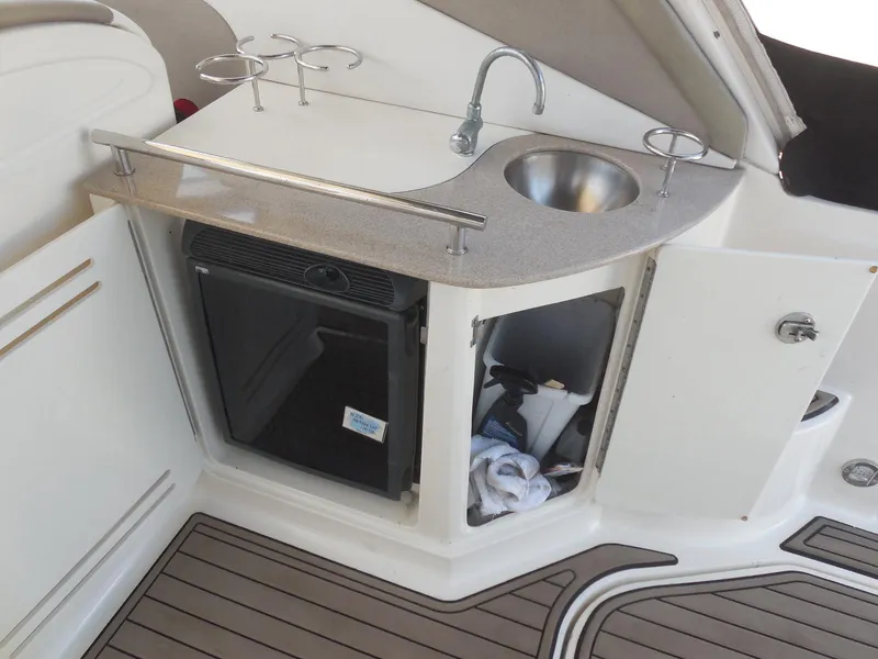 Slide: The Image of 2007 Sea Ray 290 Sundancer boat kitchenette with sink, mini-fridge, and storage. - 45