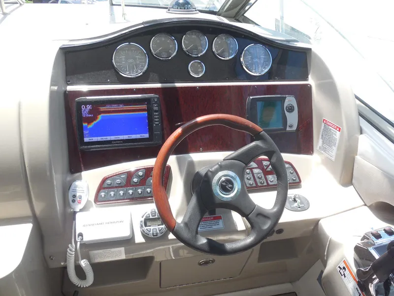 Slide: The Image of 2007 Sea Ray 290 Sundancer dashboard with steering wheel, gauges, and navigation equipment. - 46