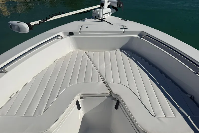 Slide: The Image of 2014 Sea Hunt Triton 220 boat interior with cushioned seating and trolling motor. - 16
