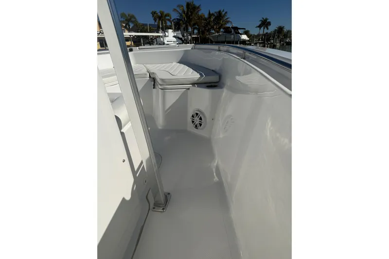 Slide: The Image of 2014 Sea Hunt Triton 220 boat interior with white seating and speaker. - 20