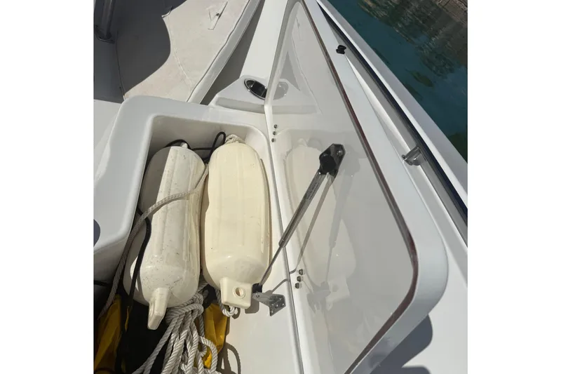 Slide: The Image of 2014 Sea Hunt Triton 220 boat storage compartment with fenders and ropes. - 23