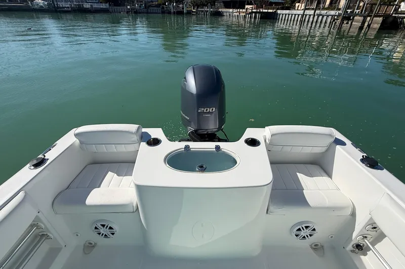 Slide: The Image of 2014 Sea Hunt Triton 220 boat interior with Yamaha 200 engine on calm water. - 30