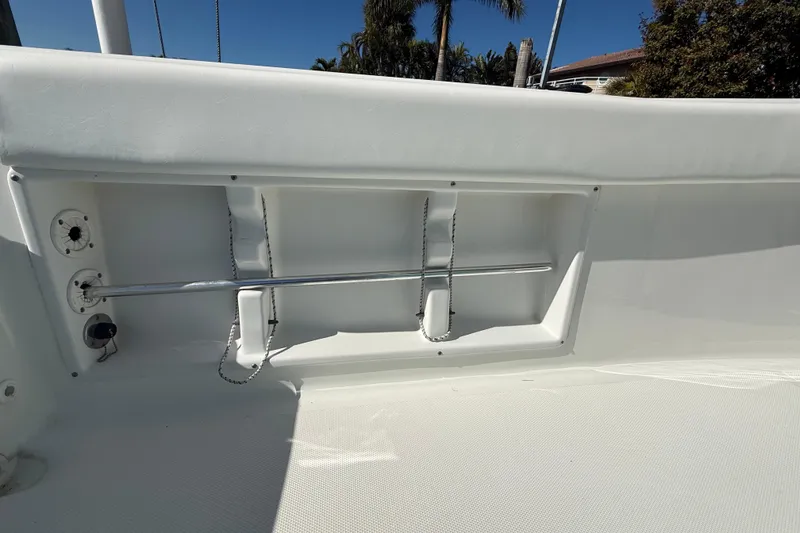 Slide: The Image of 2014 Sea Hunt Triton 220 boat interior with rod holders and storage compartment. - 33