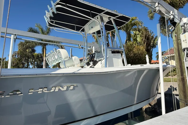 Slide: The Image of 2014 Sea Hunt Triton 220 boat docked with T-top and palm trees in background. - 45