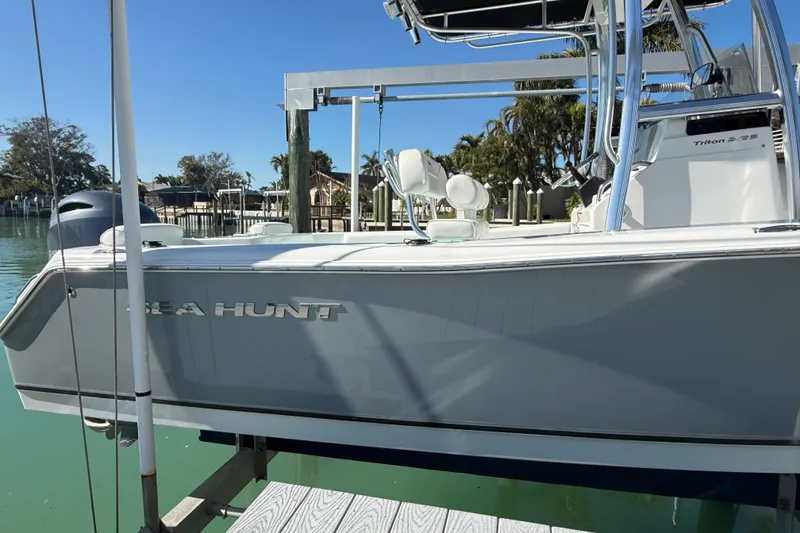 Slide: The Image of 2014 Sea Hunt Triton 220 boat docked in a sunny marina setting. - 46