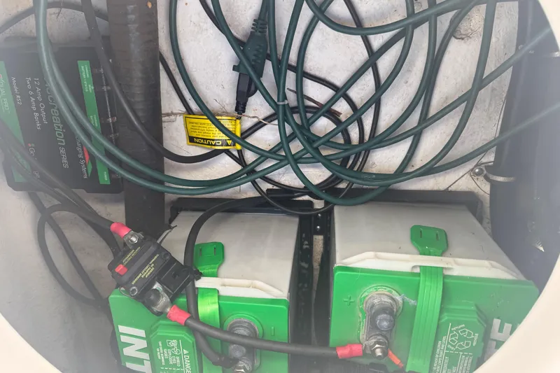 Slide: The Image of 2014 Sea Hunt Triton 220 boat battery compartment with wiring and charging system. - 50