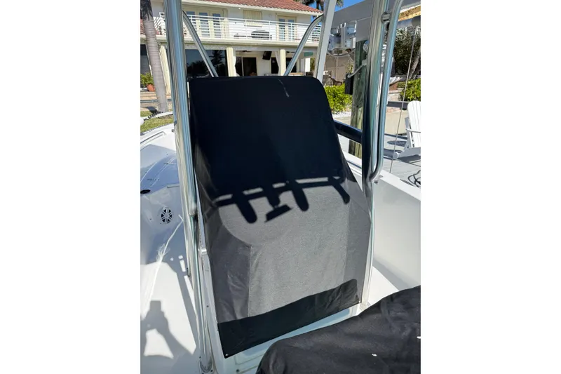 Slide: The Image of 2014 Sea Hunt Triton 220 boat console with protective cover in a sunny marina. - 52