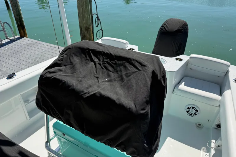 Slide: The Image of 2014 Sea Hunt Triton 220 boat interior with covered seats and console near dock. - 53