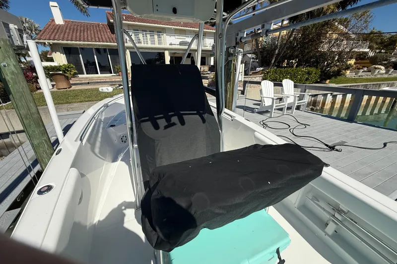 Slide: The Image of 2014 Sea Hunt Triton 220 boat docked near waterfront home, featuring covered seating. - 54