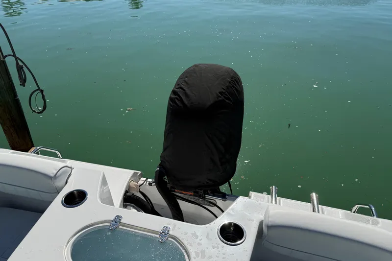 Slide: The Image of 2014 Sea Hunt Triton 220 boat with covered outboard motor on calm water. - 56