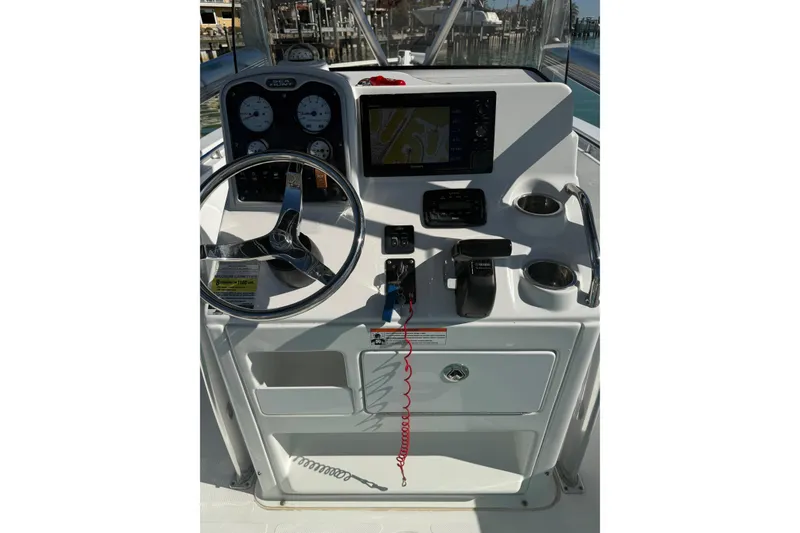 Slide: The Image of 2014 Sea Hunt Triton 220 boat dashboard with steering wheel and navigation controls. - 8