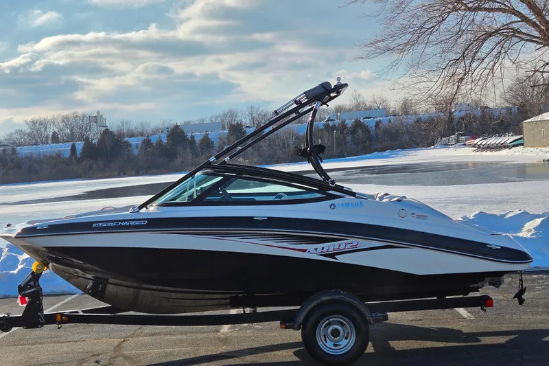 The Image of 2014 Yamaha Boats AR192 on trailer, parked near snowy lake under cloudy sky. - 0