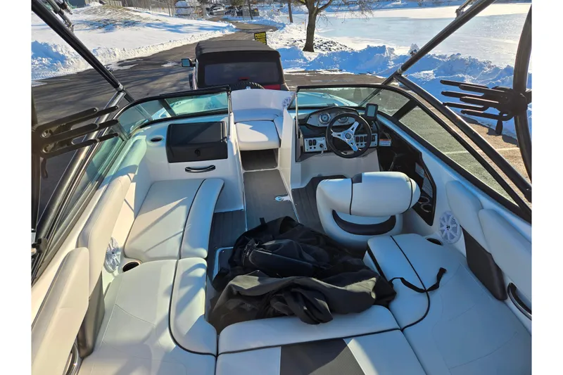 Slide: The Image of 2014 Yamaha Boats AR192 interior with white seating, steering wheel, and dashboard in snowy setting. - 10