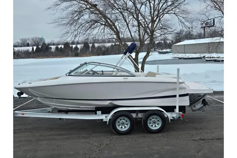 The Image of 2015 Regal 1900 ES Bowrider on trailer, parked near snowy lake. - 0