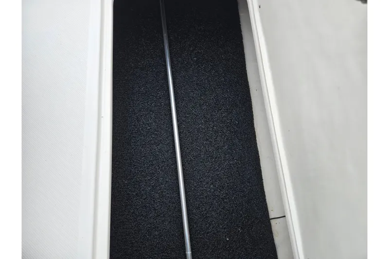 Slide: The Image of Storage compartment of 2015 Regal 1900 ES Bowrider boat with black mat lining. - 13