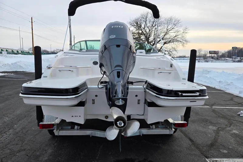 Slide: The Image of 2016 Chaparral 210 Suncoast Ski & Fish boat with outboard motor, parked on snowy pavement. - 2