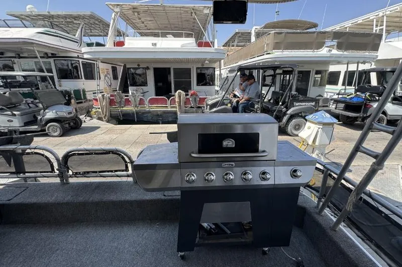 Slide: The Image of Outdoor grill on a boat deck with houseboats and golf carts in the background. - 12