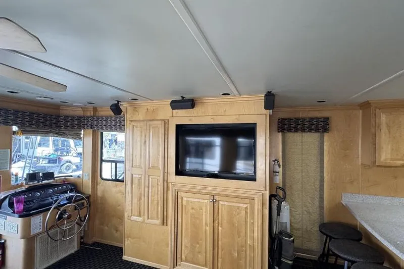 Slide: The Image of Interior of 2006 American Waterways houseboat, featuring wooden cabinetry and a mounted TV. - 14