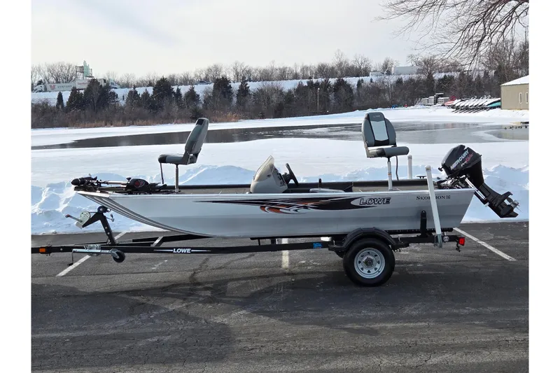 The Image of 2016 Lowe Skorpion boat on trailer, parked near snowy lake. - 0