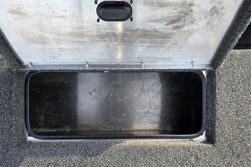 Slide: The Image of Open storage compartment in 2016 Lowe Skorpion boat, featuring carpeted interior. - 21