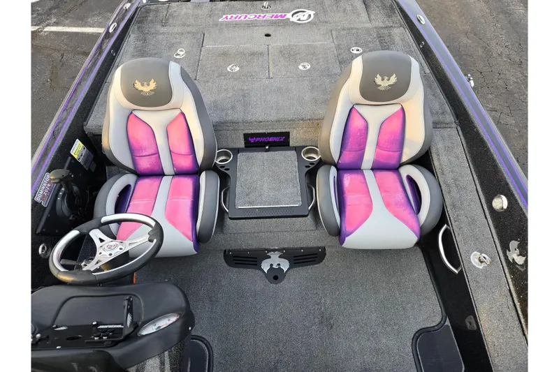 Slide: The Image of 2016 Phoenix 721 ProXP boat interior with purple and gray seats, steering wheel, and carpeted flooring. - 19