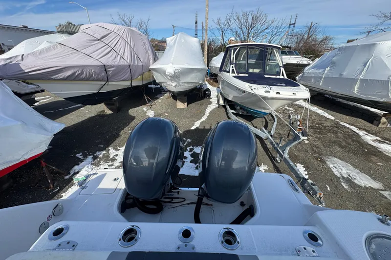 Slide: The Image of 2020 Robalo R272 Center Console boat with dual engines in a snowy storage yard. - 1