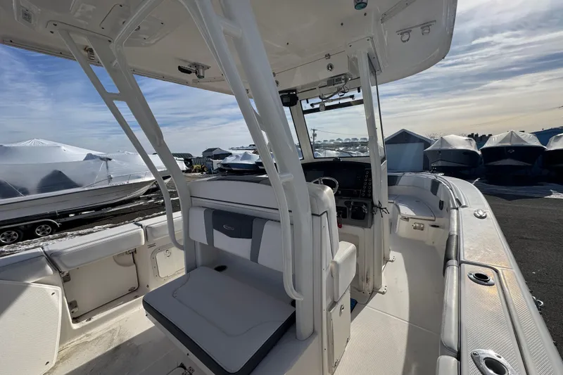 Slide: The Image of 2020 Robalo R272 Center Console boat interior with helm and seating, docked outdoors. - 3