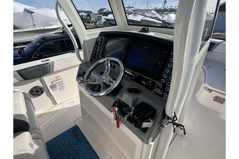 Slide: The Image of 2020 Robalo R272 Center Console boat helm with steering wheel and navigation controls. - 6