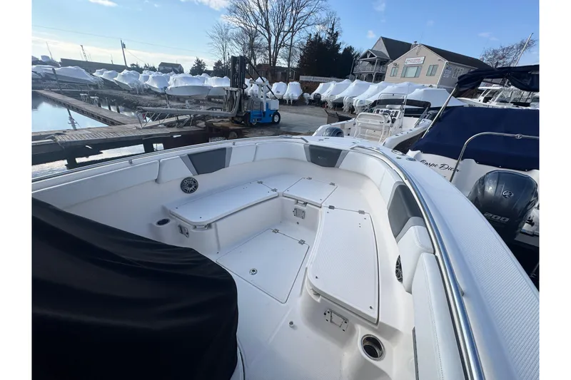 Slide: The Image of 2020 Robalo R272 Center Console boat docked, showcasing spacious seating and storage areas. - 9