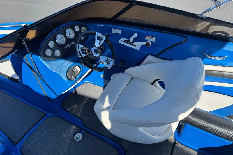 Slide: The Image of 2015 Caravelle 22 Interceptor boat cockpit with blue dashboard and white captain's chair. - 23