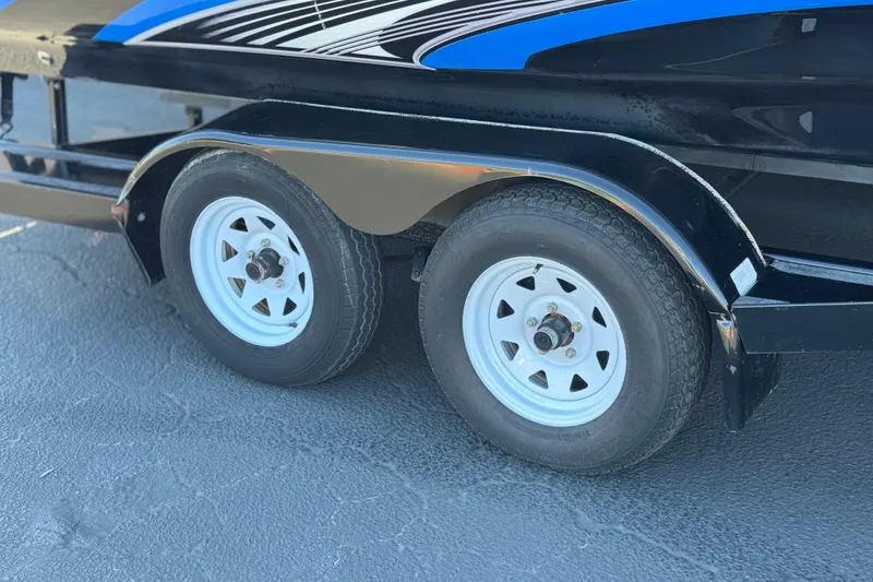 Slide: The Image of Trailer wheels of a 2015 Caravelle 22 Interceptor boat on pavement. - 26