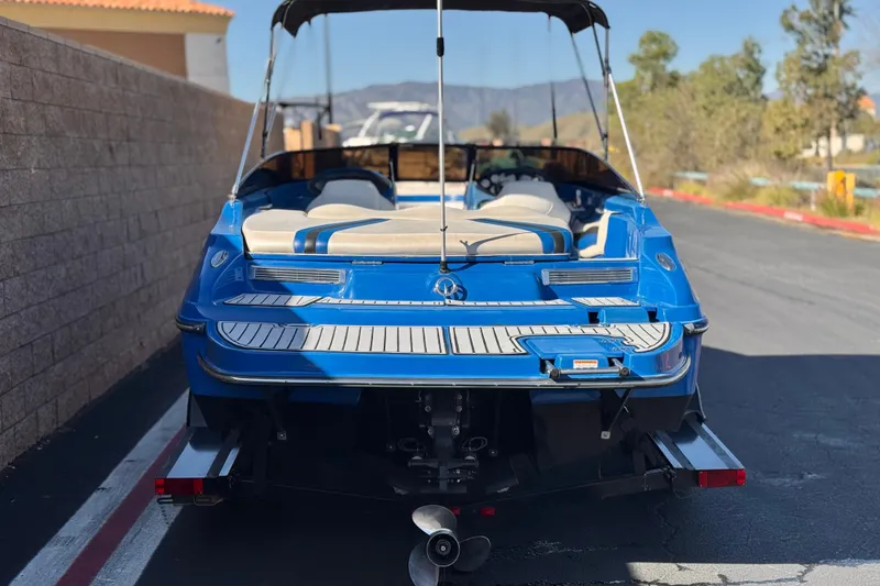 Slide: The Image of Blue 2015 Caravelle 22 Interceptor boat parked, rear view, with beige interior. - 4