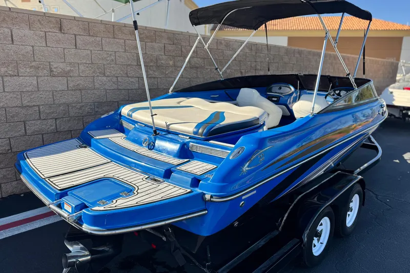 Slide: The Image of Blue 2015 Caravelle 22 Interceptor boat with canopy on trailer, parked outdoors. - 5