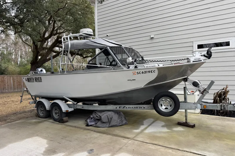 The Image of 2016 North River 21' Seahawk boat on trailer, parked beside a house. - 0
