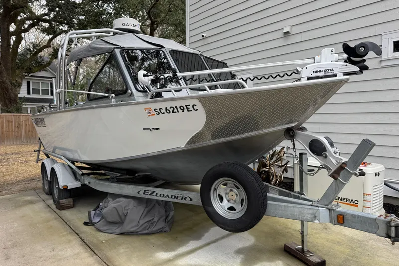 Slide: The Image of 2016 North River 21' Seahawk boat on trailer, parked beside a house. - 2