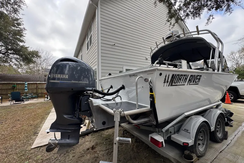 Slide: The Image of 2016 North River 21' Seahawk boat with Yamaha motor on trailer, parked beside house. - 22