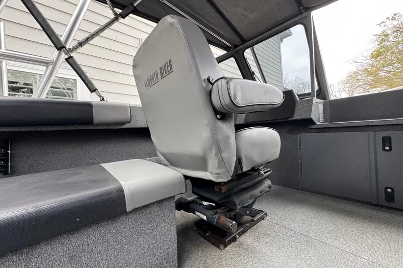 Slide: The Image of Interior of a 2016 North River 21' Seahawk boat, featuring a gray captain's chair. - 23