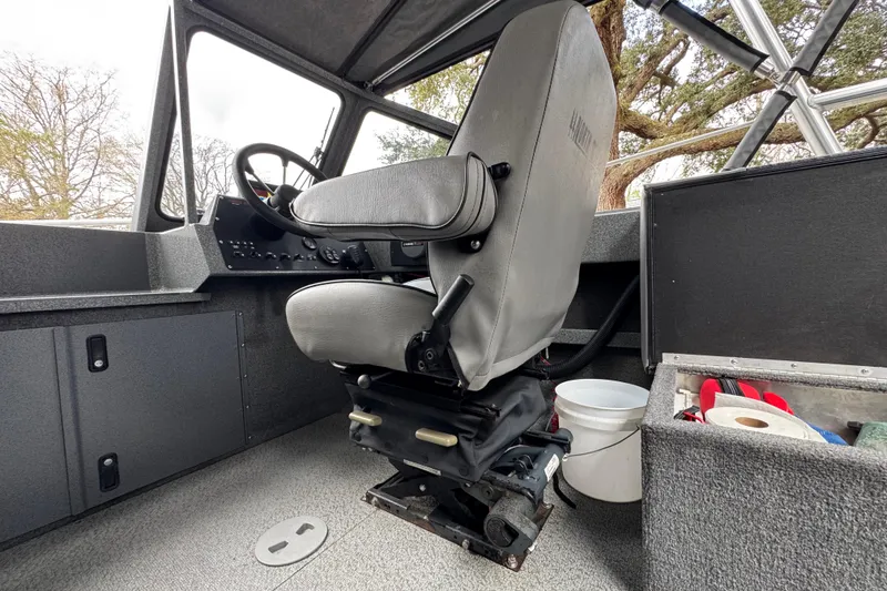 Slide: The Image of Interior of a 2016 North River 21' Seahawk boat, featuring a captain's seat and steering console. - 27