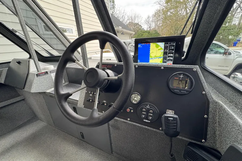 Slide: The Image of 2016 North River 21' Seahawk boat dashboard with steering wheel and navigation display. - 28