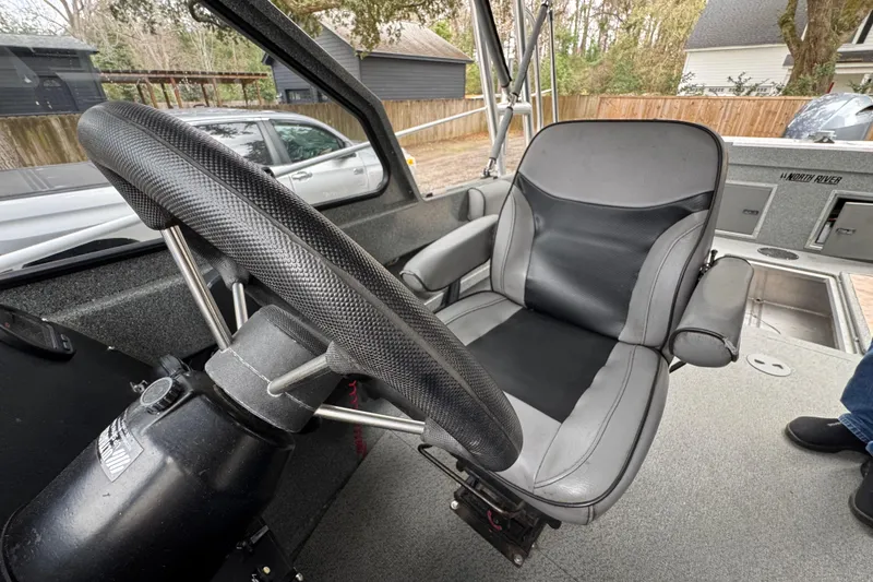 Slide: The Image of Interior of a 2016 North River 21' Seahawk boat, featuring steering wheel and seat. - 36
