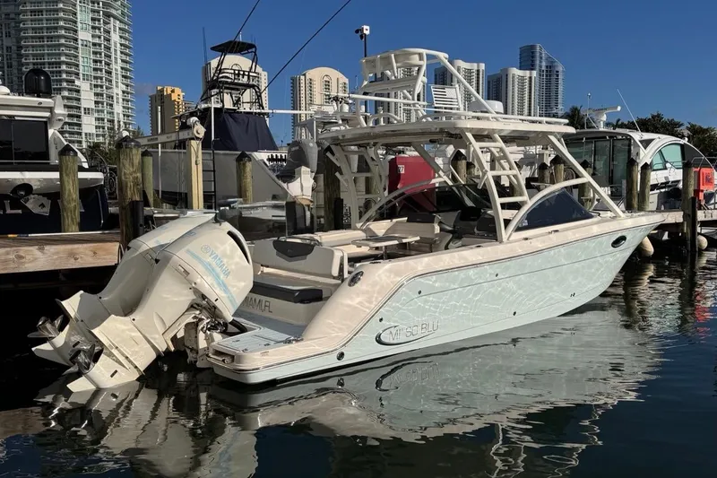 The Image of 2021 Robalo R317 Dual Console boat docked in marina, city skyline background. - 0