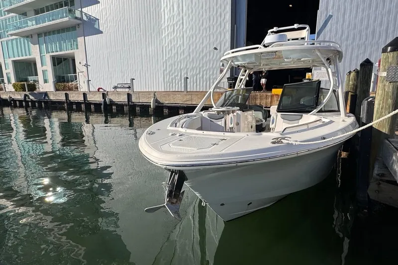 Slide: The Image of 2021 Robalo R317 Dual Console boat docked by modern building. - 10