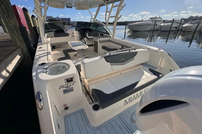 Slide: The Image of 2021 Robalo R317 Dual Console boat docked, featuring spacious seating and modern design. - 12
