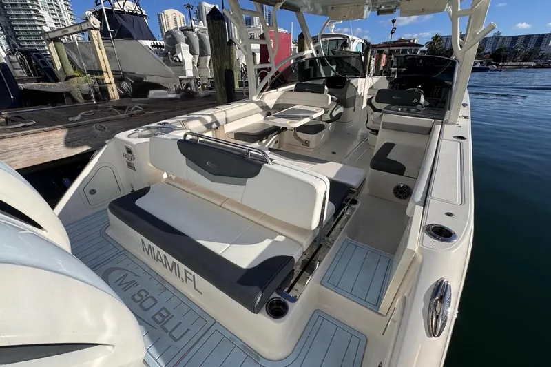 Slide: The Image of 2021 Robalo R317 Dual Console boat docked in Miami, featuring spacious seating and modern design. - 14