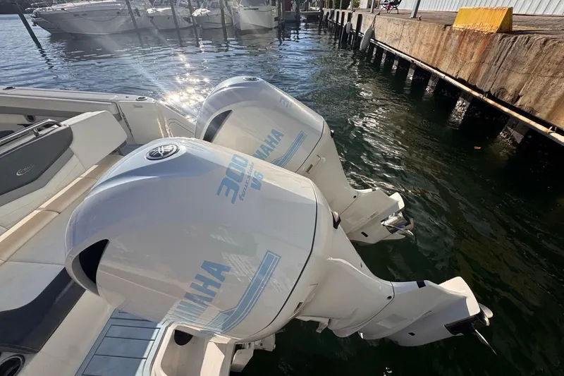 Slide: The Image of 2021 Robalo R317 Dual Console with twin Yamaha 300 engines docked by the water. - 16