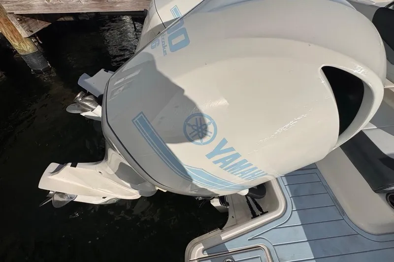 Slide: The Image of Yamaha outboard engine on 2021 Robalo R317 Dual Console boat, docked by water. - 18